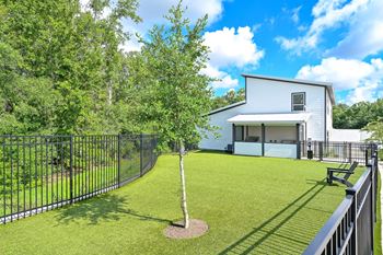 a yard with a bench and tree in front of a white house at Ironwood Flats, Brandon, Florida